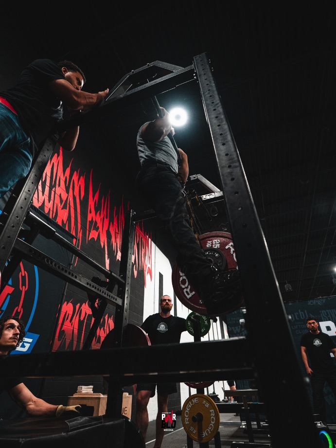 Nick performs a weighted chin-up with plates suspended from his belt.